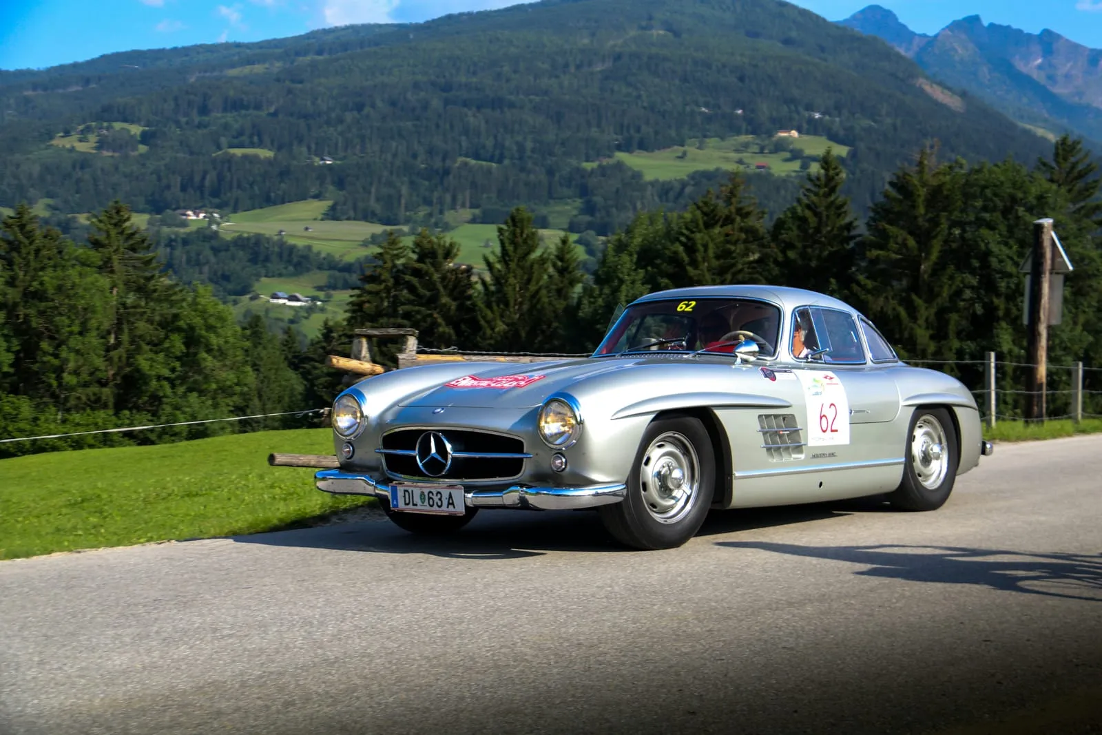 Silberner Mercedes 300 SL Oldtimer auf einer Alpenstraße